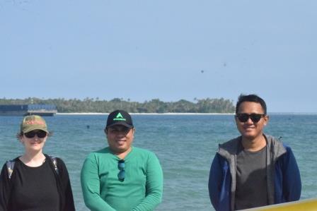 Charlotte, Pak Dandi, and Gede at the Kahyapu ferry harbour, with Pulau Dua as the background.