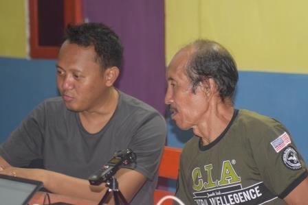 Gede with Datuk Ishar Timius Kaitora, checking the recording and transcription for the cultural tools and traditional clothing