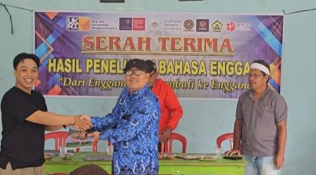 Engga Zakaria Sangian symbolically presents the Junior-High School Enggano textbook to a representative school teacher